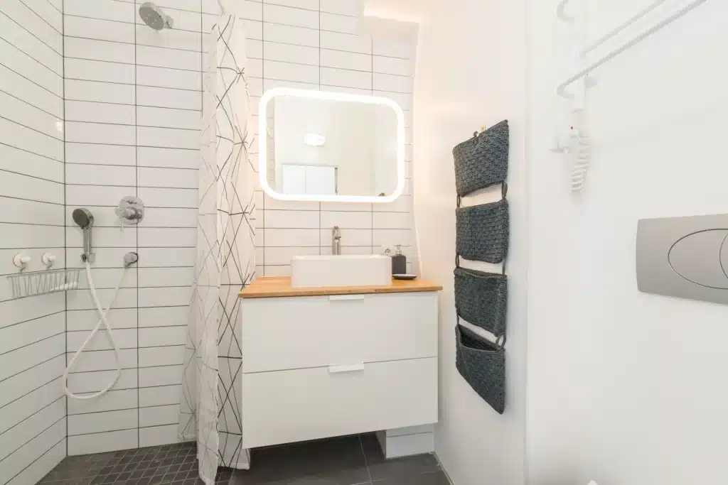 Mueble auxiliar de baño en un baño actual decorado en tonos blancos